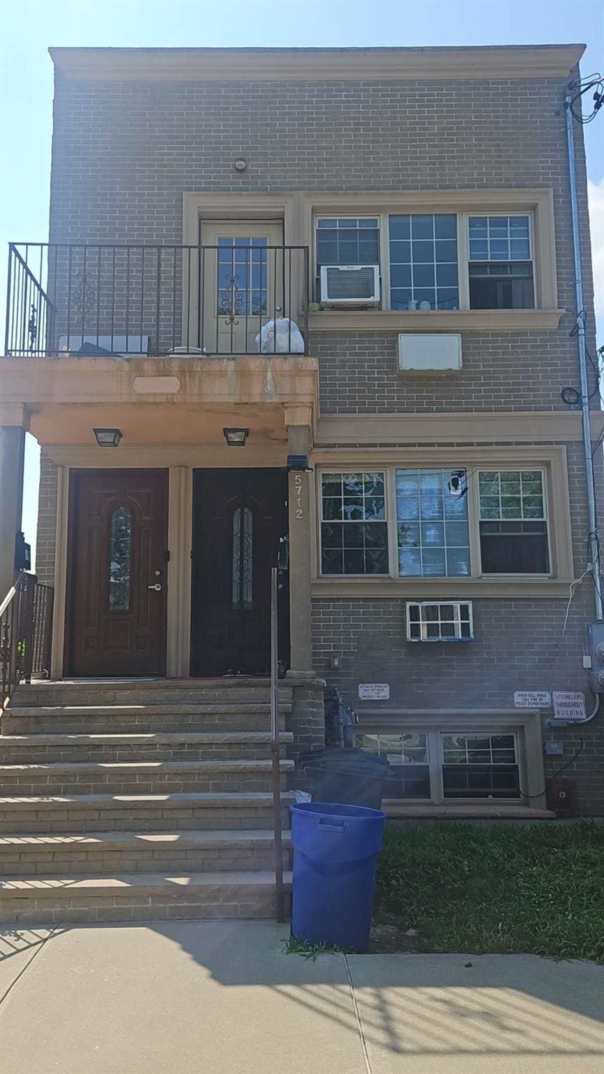57-12 153th St, Flushing, NY 11355 - view of front of home with a balcony and brick siding