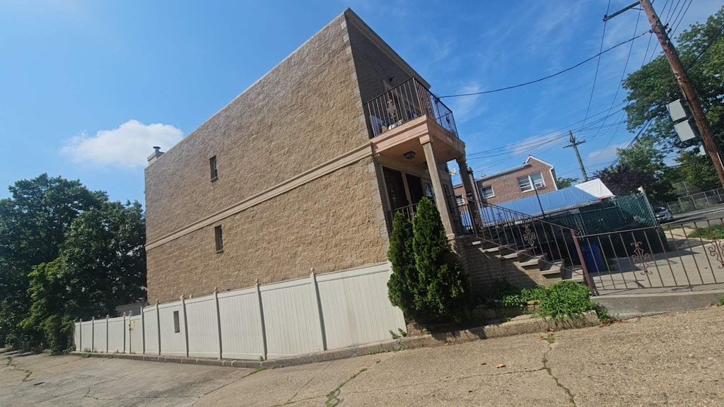 57-12 153th St, Flushing, NY 11355 - view of side of property featuring a balcony and stairs