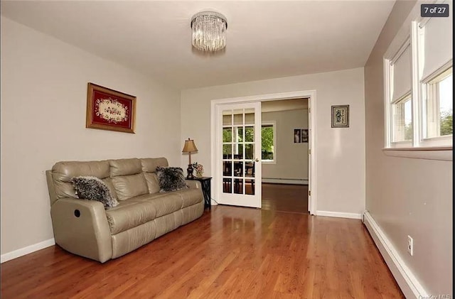 6 Schevchenko Pl, Monsey, NY 10977 - living room featuring wood finished floors, a baseboard radiator, french doors, a baseboard heating unit, and a chandelier