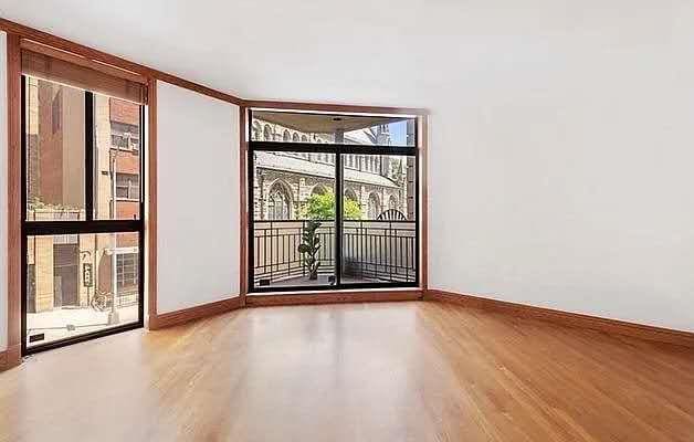 8 W 65th St Unit 5A, New York Manhattan, NY 10023 - unfurnished room featuring wood finished floors and a wall of windows