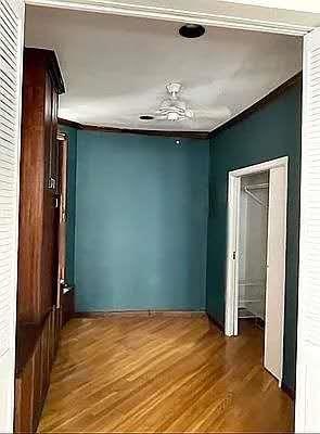 8 W 65th St Unit 5A, New York Manhattan, NY 10023 - spare room featuring wood finished floors, crown molding, and a ceiling fan