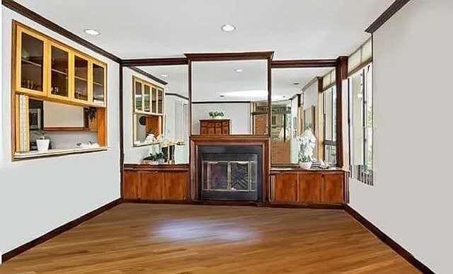 8 W 65th St Unit 5A, New York Manhattan, NY 10023 - unfurnished living room featuring a glass covered fireplace, wood finished floors, and crown molding
