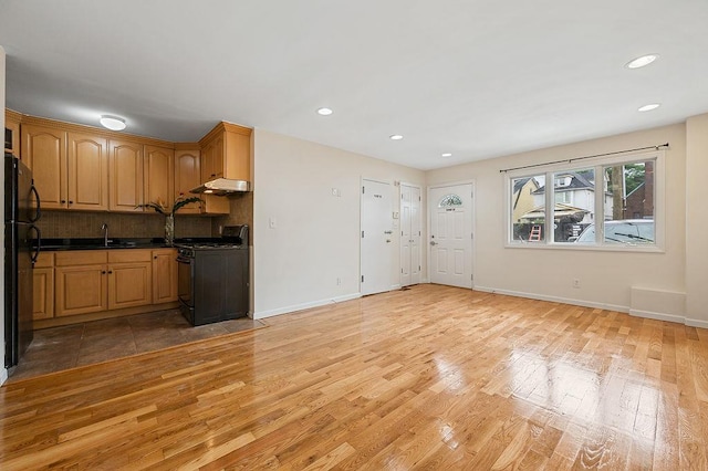 16407 Goethals Ave, Jamaica, NY 11432 - kitchen featuring black appliances, light wood-style floors, backsplash, recessed lighting, and dark countertops