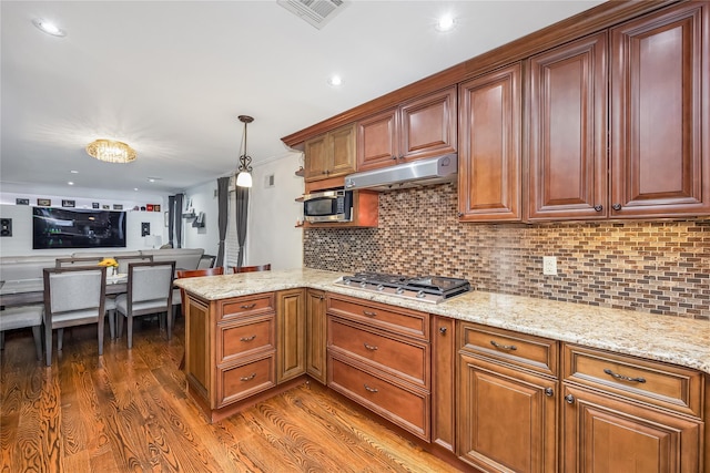 487 Court Ave, Cedarhurst, NY 11516 - kitchen featuring appliances with stainless steel finishes, under cabinet range hood, wood finished floors, decorative backsplash, and recessed lighting