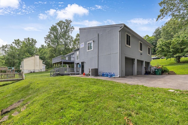 49 Flower Rd, Hopewell Junction, NY 12533 - view of side of property featuring concrete driveway, a deck, an attached garage, and a lawn