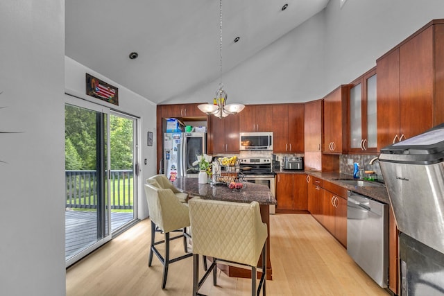 49 Flower Rd, Hopewell Junction, NY 12533 - kitchen with appliances with stainless steel finishes, light wood finished floors, high vaulted ceiling, a chandelier, and glass insert cabinets