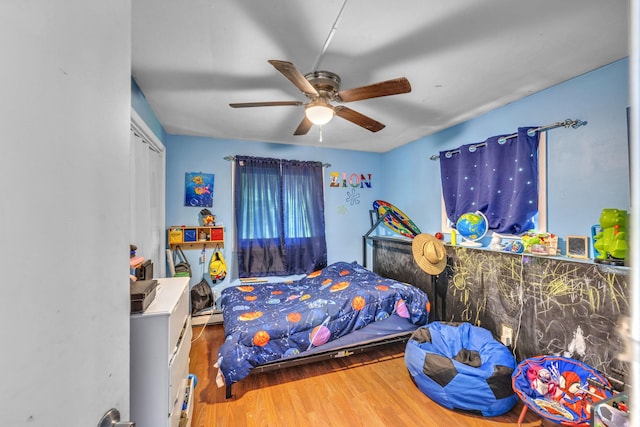 49 Flower Rd, Hopewell Junction, NY 12533 - bedroom with wood finished floors, ceiling fan, a baseboard radiator, and a closet