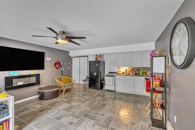 49 Flower Rd, Hopewell Junction, NY 12533 - kitchen with freestanding refrigerator, white range with gas cooktop, a ceiling fan, decorative backsplash, and white cabinetry