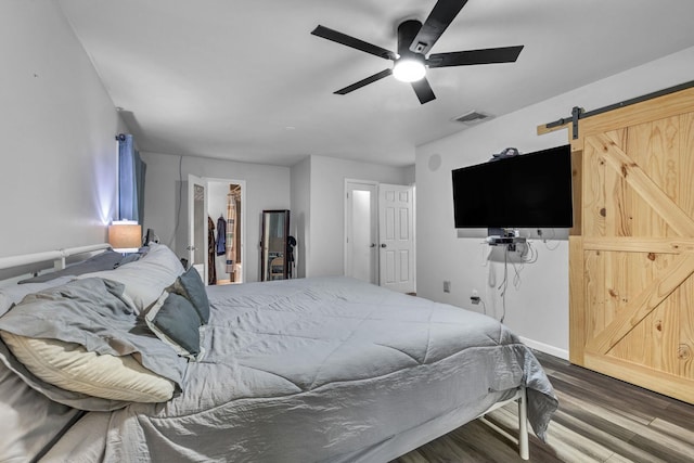 49 Flower Rd, Hopewell Junction, NY 12533 - bedroom with a barn door, wood finished floors, a walk in closet, and ceiling fan