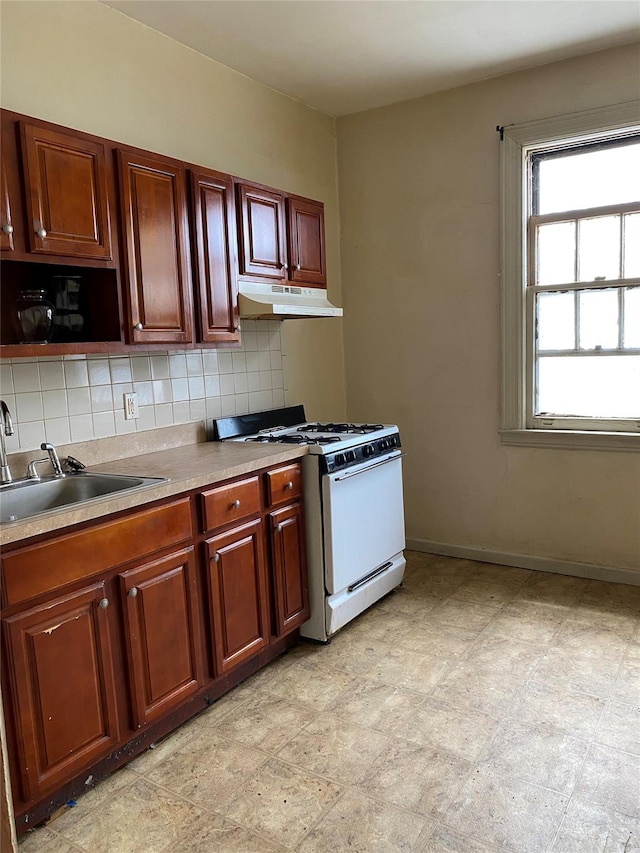 1624 Seddon St, Bronx, NY 10461 - kitchen with white gas range, under cabinet range hood, backsplash, and light countertops