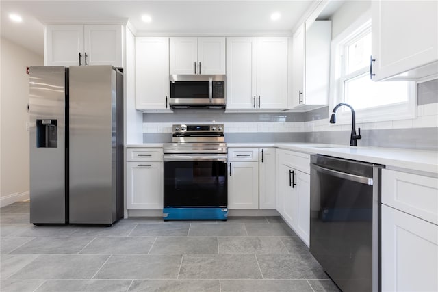 37 Martha St, Freeport, NY 11520 - kitchen with stainless steel appliances, light countertops, white cabinets, backsplash, and recessed lighting