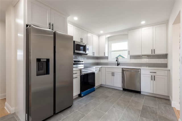 37 Martha St, Freeport, NY 11520 - kitchen featuring stainless steel appliances, light countertops, white cabinets, tasteful backsplash, and recessed lighting