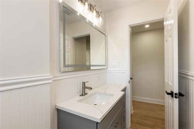 37 Martha St, Freeport, NY 11520 - bathroom with vanity, a wainscoted wall, wood finished floors, and a decorative wall