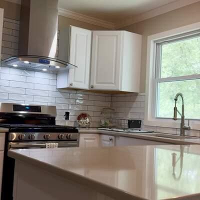 16-18 Claremont Ct, Middletown, NY 10940 - kitchen with wall chimney range hood, crown molding, white cabinetry, stainless steel range oven, and plenty of natural light