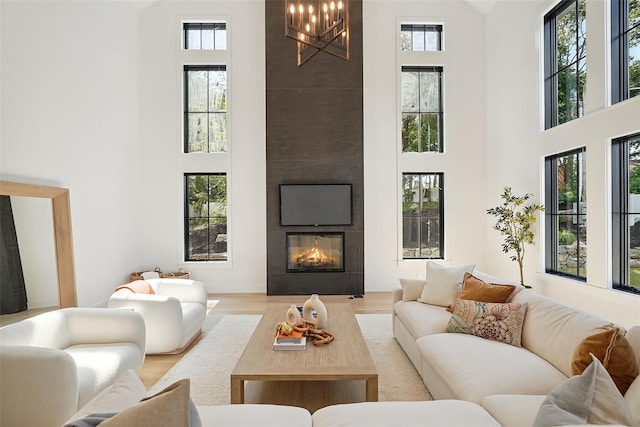 23 Sylvan Rd, Rye Brook, NY 10573 - living room featuring a towering ceiling, plenty of natural light, a large fireplace, and a chandelier
