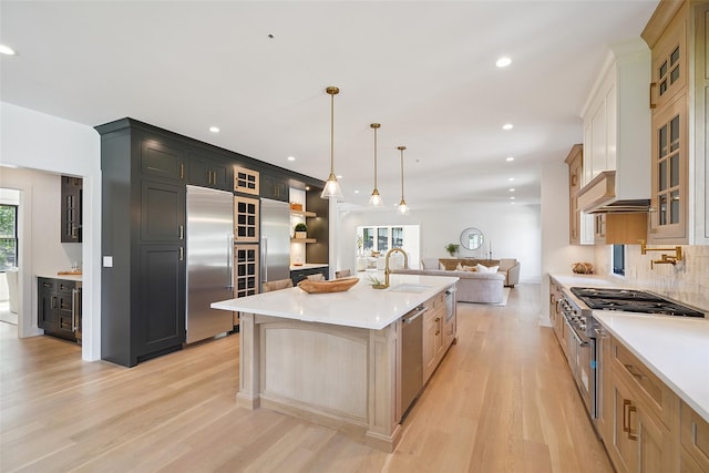 23 Sylvan Rd, Rye Brook, NY 10573 - kitchen with premium appliances, light countertops, light wood finished floors, recessed lighting, and glass insert cabinets