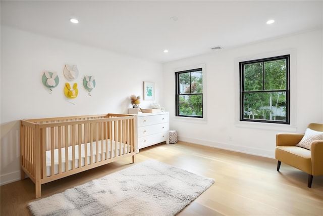 23 Sylvan Rd, Rye Brook, NY 10573 - bedroom with light wood-type flooring, recessed lighting, and a nursery area
