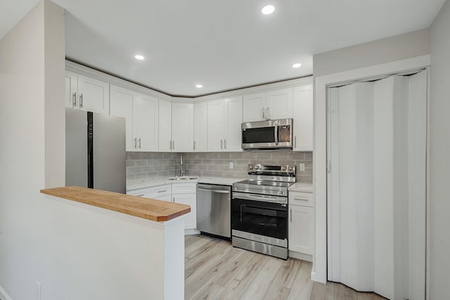 3 Auburn Ave, Bay Shore, NY 11706 - kitchen with appliances with stainless steel finishes, light countertops, white cabinets, tasteful backsplash, and recessed lighting