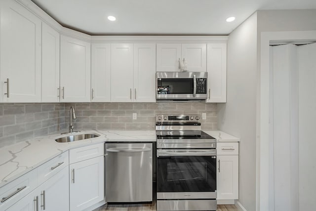 3 Auburn Ave, Bay Shore, NY 11706 - kitchen with stainless steel appliances, white cabinetry, backsplash, and recessed lighting