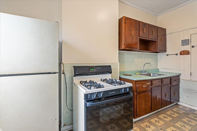 59-30 70th Ave, Ridgewood, NY 11385 - kitchen featuring freestanding refrigerator, range with gas stovetop, light countertops, crown molding, and backsplash