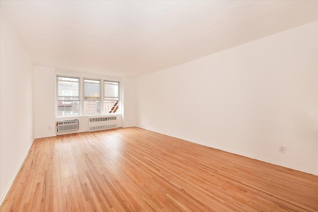 400 E 17th St Unit 600, Brooklyn, NY 11226 - unfurnished room featuring radiator heating unit, light wood-style floors, and a wall unit AC