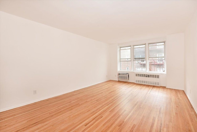 400 E 17th St Unit 600, Brooklyn, NY 11226 - empty room with radiator heating unit, light wood-type flooring, and a wall mounted AC