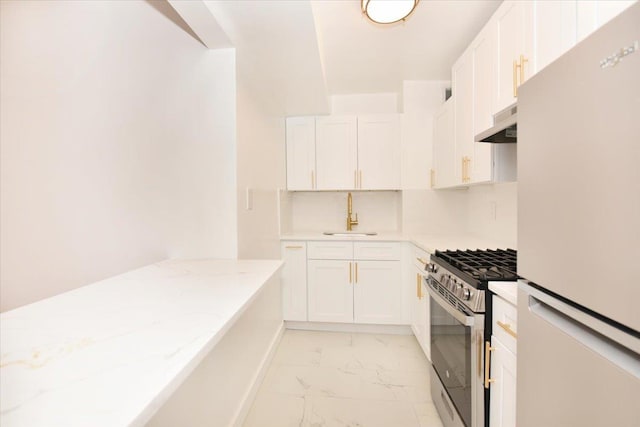 400 E 17th St Unit 600, Brooklyn, NY 11226 - kitchen with freestanding refrigerator, stainless steel gas range, light marble finish floors, under cabinet range hood, and white cabinets