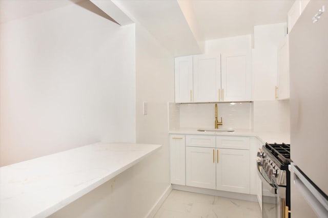 400 E 17th St Unit 600, Brooklyn, NY 11226 - kitchen featuring stainless steel range with gas cooktop, freestanding refrigerator, light marble finish floors, white cabinets, and light stone countertops