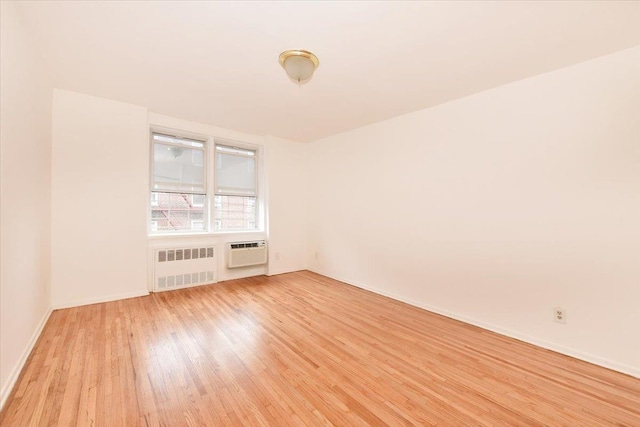 400 E 17th St Unit 600, Brooklyn, NY 11226 - spare room featuring radiator heating unit, a wall mounted air conditioner, and light wood finished floors