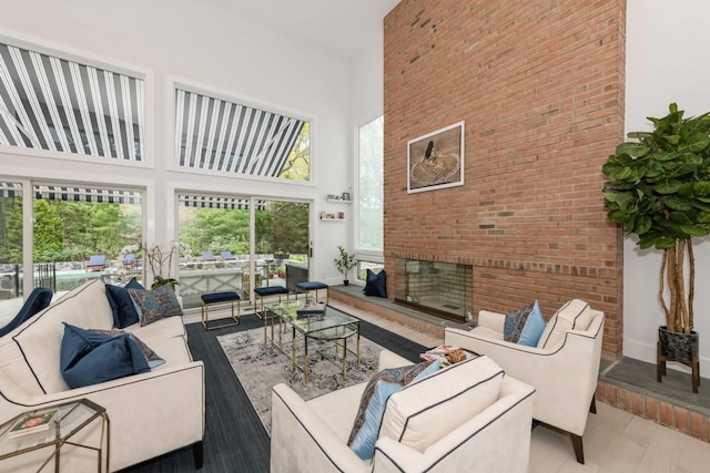 715 Hands Creek Rd, East Hampton, NY 11937 - living area with a towering ceiling, wood finished floors, plenty of natural light, and a fireplace with raised hearth