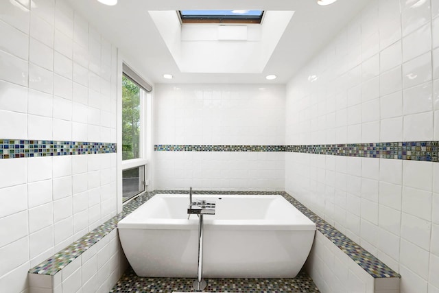715 Hands Creek Rd, East Hampton, NY 11937 - bathroom featuring tile walls, a freestanding bath, a skylight, and recessed lighting