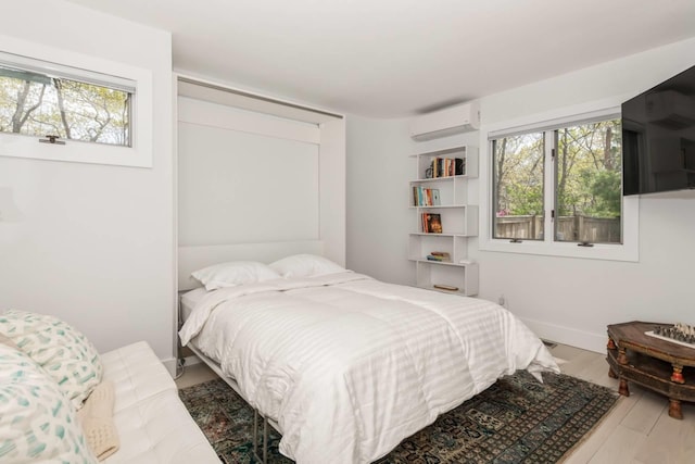 715 Hands Creek Rd, East Hampton, NY 11937 - bedroom with a wall mounted air conditioner, multiple windows, and wood finished floors