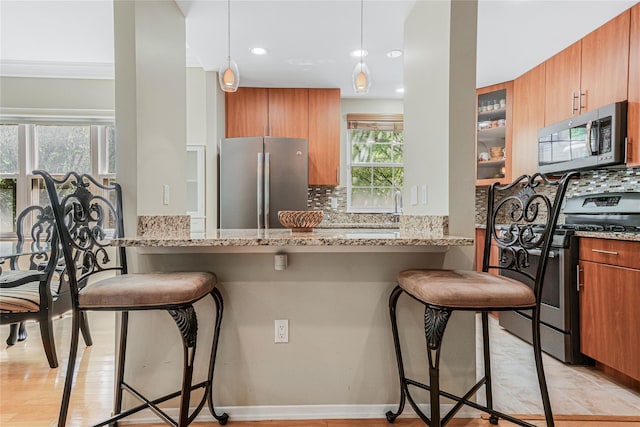 55 Oceana Dr E Unit 1B, Brooklyn, NY 11235 - kitchen featuring appliances with stainless steel finishes, a breakfast bar area, light stone countertops, and recessed lighting