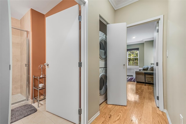 55 Oceana Dr E Unit 1B, Brooklyn, NY 11235 - laundry area featuring stacked washing machine and dryer, crown molding, and light wood-type flooring