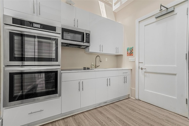 55 Oceana Dr E Unit 1B, Brooklyn, NY 11235 - kitchen featuring appliances with stainless steel finishes, light wood finished floors, white cabinets, and light countertops