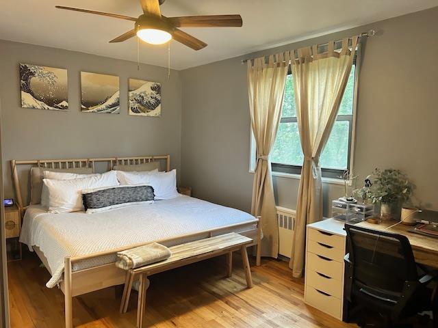 199-39 19th Ave Upper, Upper, Whitestone, NY 11357 - bedroom with light wood-type flooring, radiator, ceiling fan, and a desk