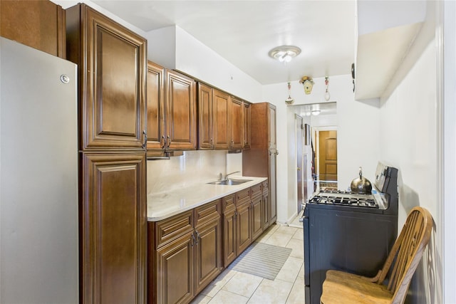 1472 Needham Ave, Bronx, NY 10469 - kitchen with black gas range oven, freestanding refrigerator, light countertops, and light tile patterned flooring
