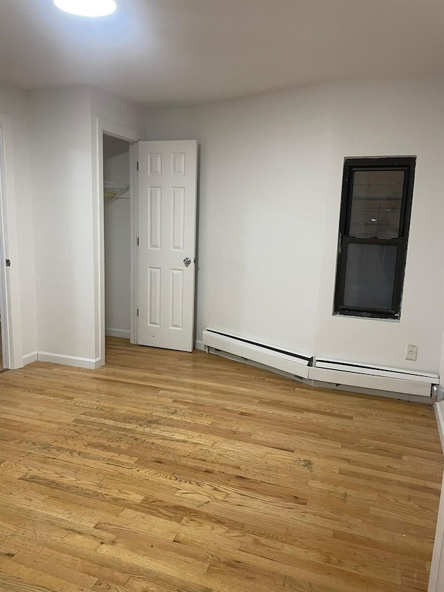 782 Cauldwell Ave, Bronx, NY 10456 - unfurnished bedroom with a baseboard radiator and light wood-style flooring