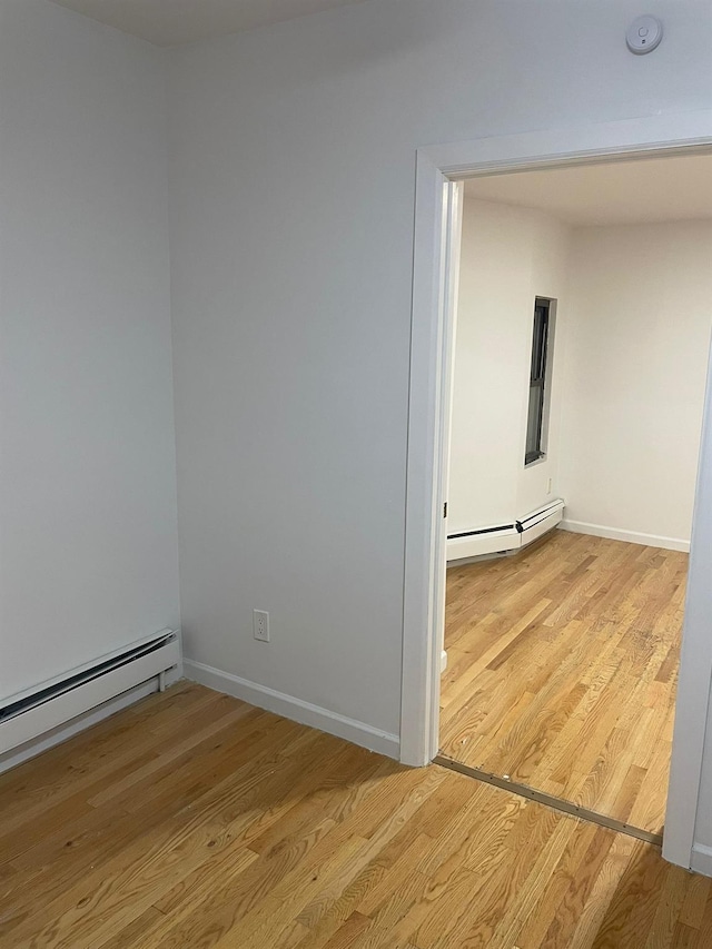 782 Cauldwell Ave, Bronx, NY 10456 - empty room with baseboard heating, a smoke detector, and light wood-style floors