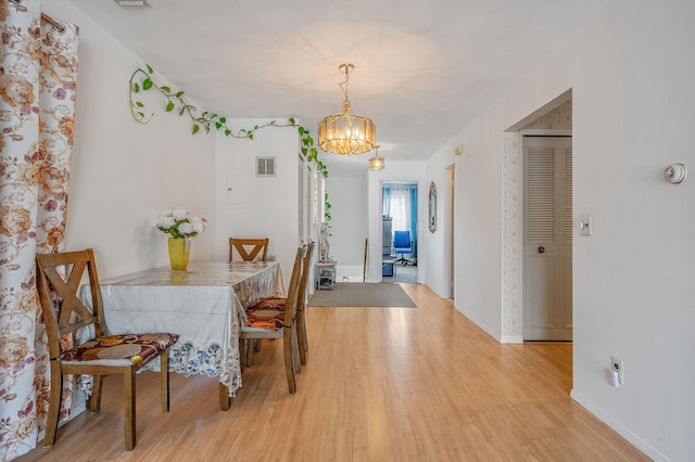 199 Cambridge Dr E, Copiague, NY 11726 - dining space with light wood-style flooring and a chandelier