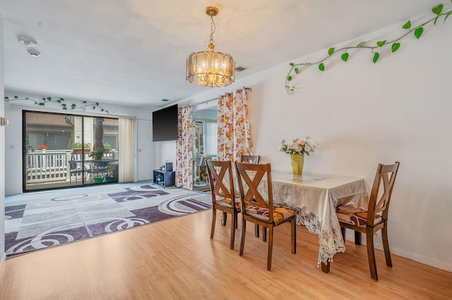 199 Cambridge Dr E, Copiague, NY 11726 - dining area featuring a chandelier and wood finished floors