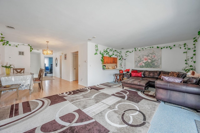 199 Cambridge Dr E, Copiague, NY 11726 - living area with a chandelier and light wood-type flooring