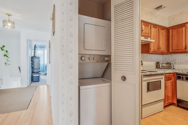 199 Cambridge Dr E, Copiague, NY 11726 - laundry room with stacked washing machine and dryer and light wood-style flooring