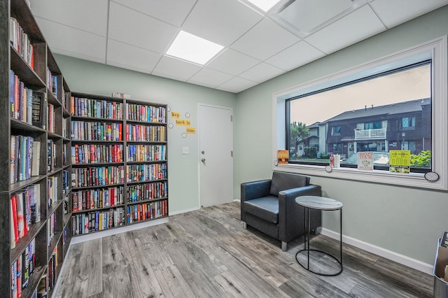 199 Cambridge Dr E, Copiague, NY 11726 - living area with wood finished floors, wall of books, and a paneled ceiling