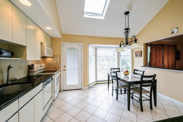 21 Hillvale Rd, Syosset, NY 11791 - kitchen featuring white appliances, vaulted ceiling, a skylight, dark countertops, and tasteful backsplash