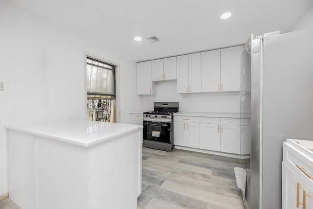 975 E 178th St, Bronx, NY 10460 - kitchen featuring appliances with stainless steel finishes, white cabinetry, a peninsula, light countertops, and recessed lighting