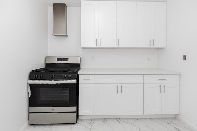 975 E 178th St, Bronx, NY 10460 - kitchen with stainless steel gas stove, light marble finish flooring, light countertops, and white cabinetry