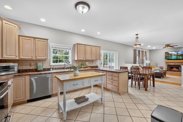 70 Hosner Mountain Rd, Hopewell Junction, NY 12533 - kitchen with light brown cabinetry, stainless steel appliances, backsplash, a ceiling fan, and a lit fireplace