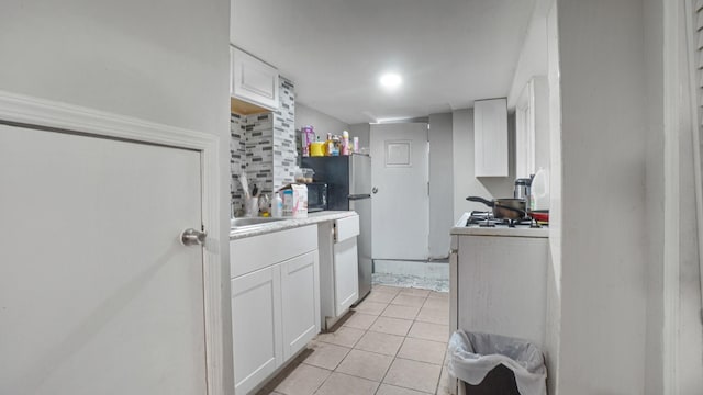 164-02 107th Ave, Jamaica, NY 11433 - kitchen with white cabinets, light tile patterned flooring, light countertops, and tasteful backsplash