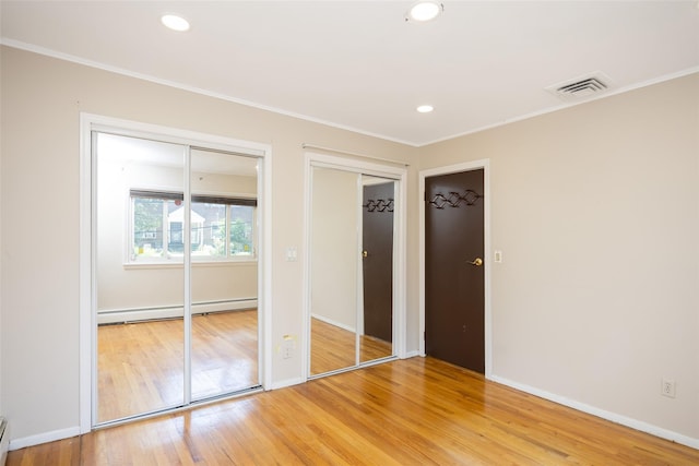 15 Linden St, Great Neck, NY 11021 - unfurnished bedroom with a baseboard radiator, two closets, light wood finished floors, ornamental molding, and recessed lighting